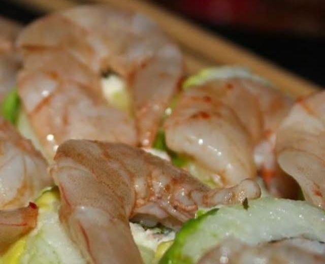Camarones grandes sobre un rollo cubierto de aguacate